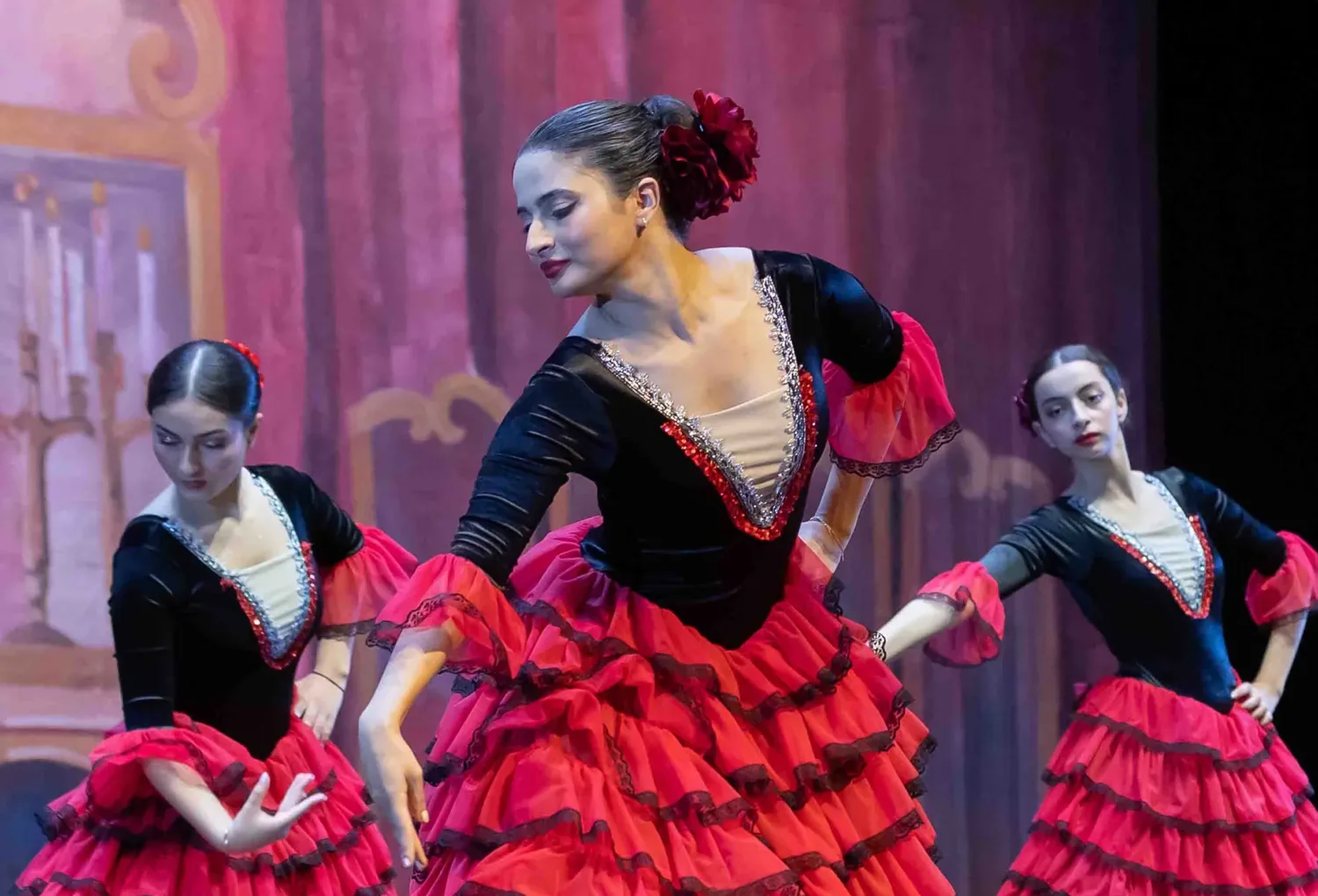 Trio de danseuses en robes de flamenco rouges sur scène, Colibri Centre Artistique