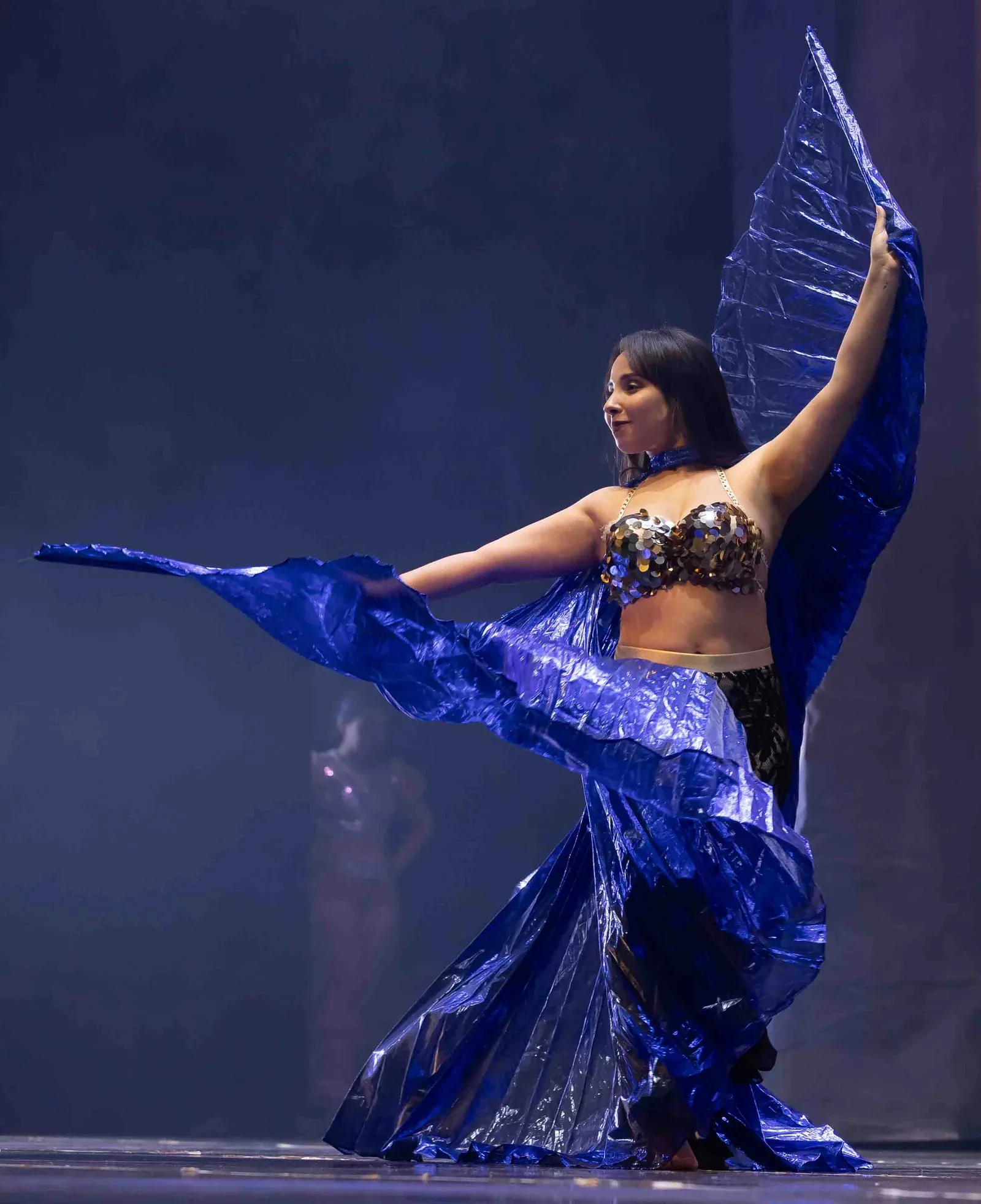 Danseuse aux ailes bleues déployées lors d’un spectacle du Colibri Centre Artistique