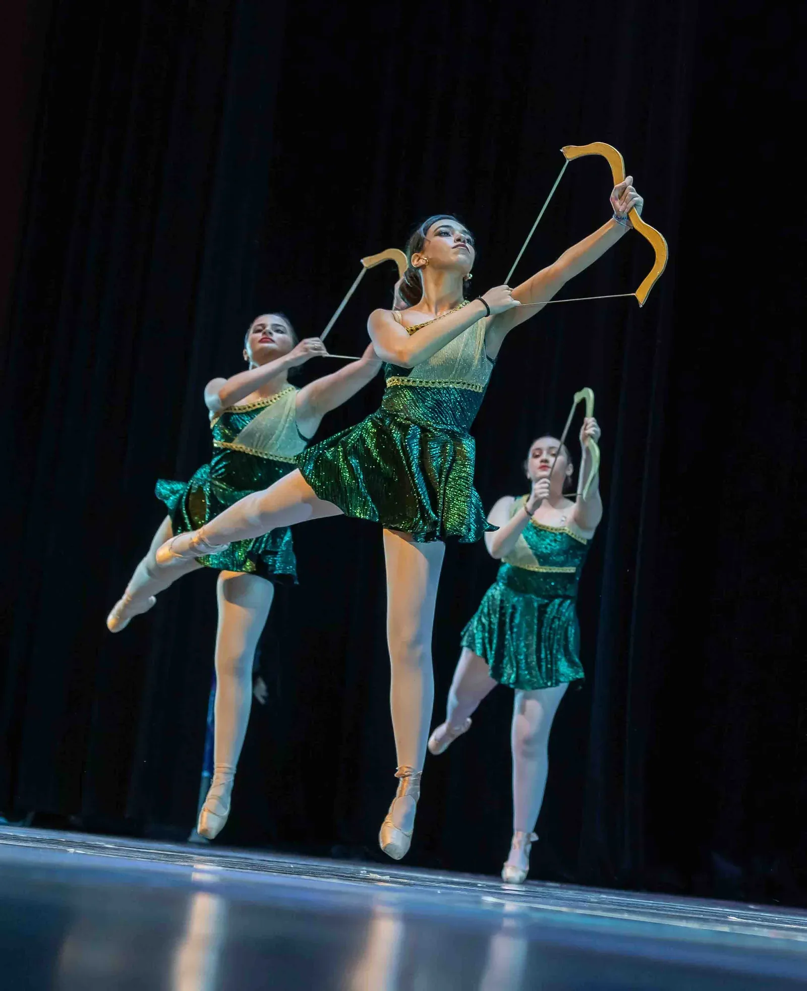 Trio de danseuses classiques aux arcs dorés sur scène au Colibri Centre Artistique